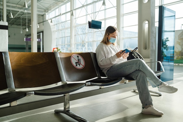 Woman sitting in airport lounge and looking at her passport