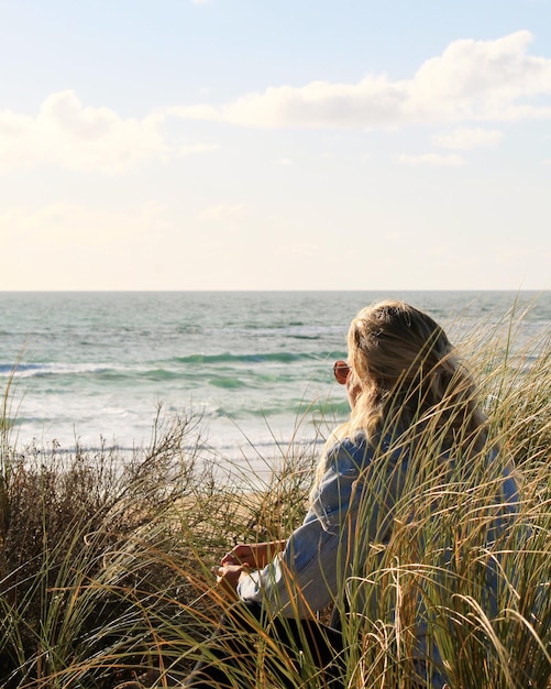 Photo woman sitting at beach