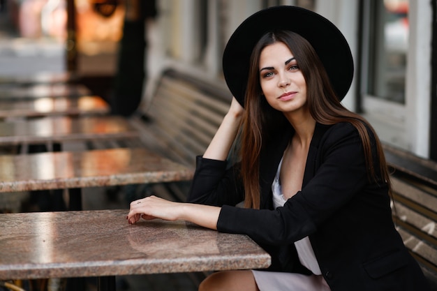 A woman sitting on a bench near the cafe. High quality