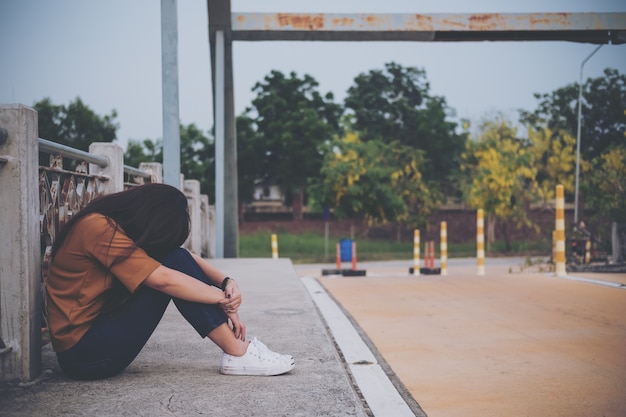 woman sitting on the bridge with feeling sad