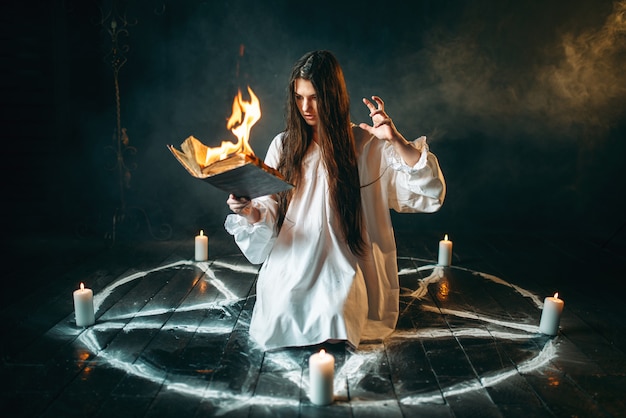 Woman sitting in burning pentagram circle, magic