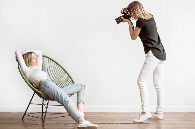 Woman sitting on a chair and photographer