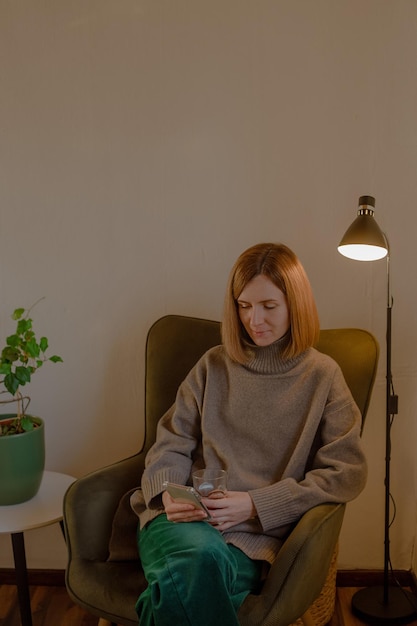 Woman sitting in chair with phone in hands