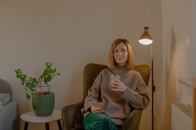 Woman sitting in chair with phone in hands