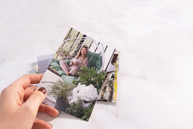 Woman sitting at desk and looking at printed photos remember nostalgia for a day of rest photography cards background Mock up