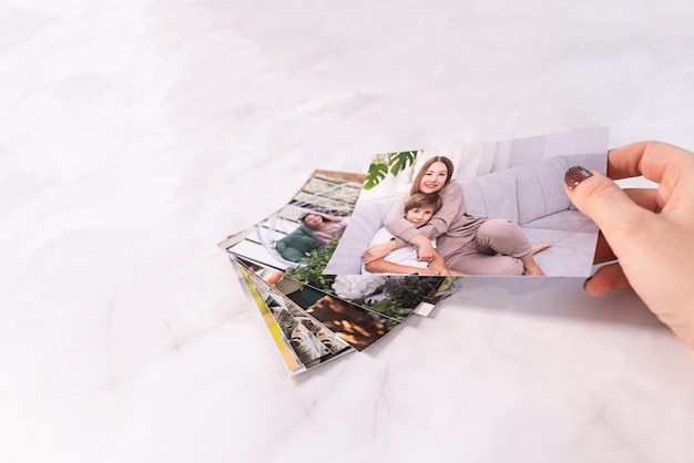 Woman sitting at desk and looking at printed photos remember nostalgia for a day of rest photography cards background Mock up