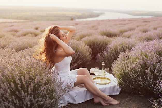 Woman sitting in a field of lavender and enjoying the moment