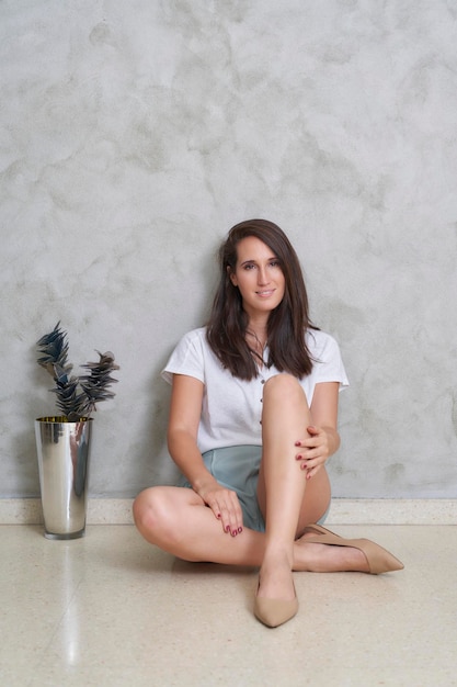 Woman sitting on the floor at home next to decoration