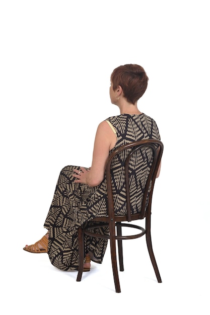 Woman sitting from the back and side in a dress and sandals on white background