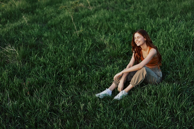 Woman sitting on green grass in nature in a park view from above