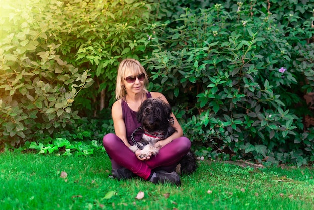 Woman sitting on the lawn with her Catalan shepherd dog Pets bring happiness Love for animals