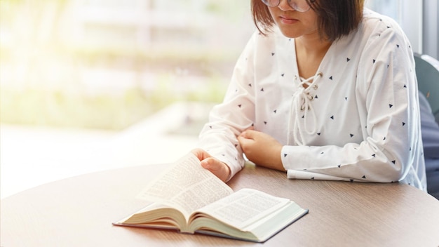 Woman sitting near the window reading a book