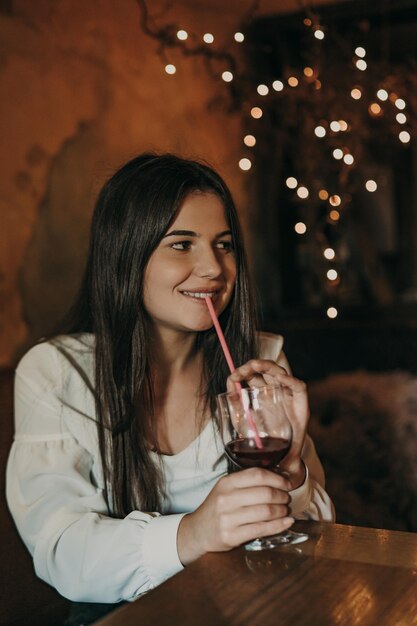 Woman sitting in a nightclub and drink cocktail.