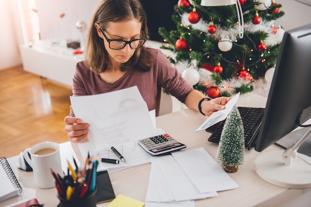 Woman sitting at the office desk and reading letter