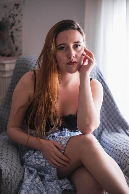 Woman sitting posing next to a window