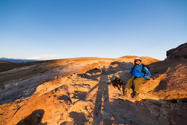 Photo woman sitting on rock formation against clear sky