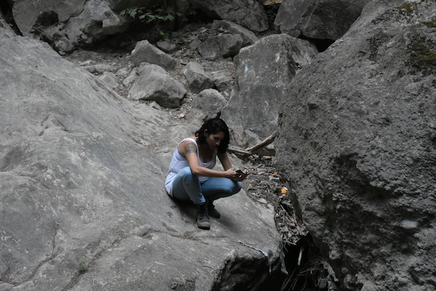 Photo woman sitting on rock