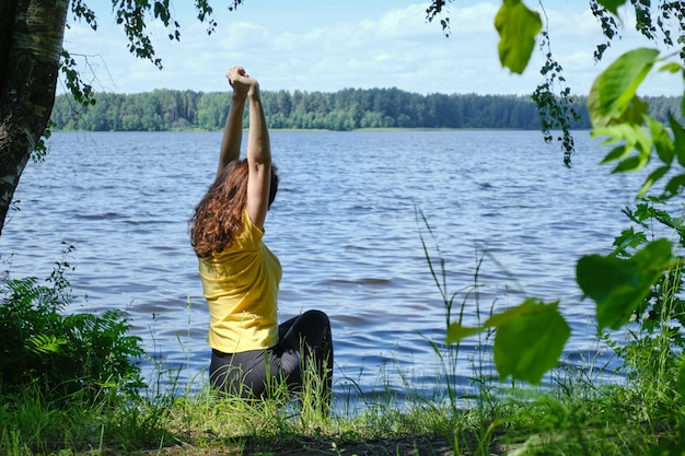 Woman sitting on the shore with lake