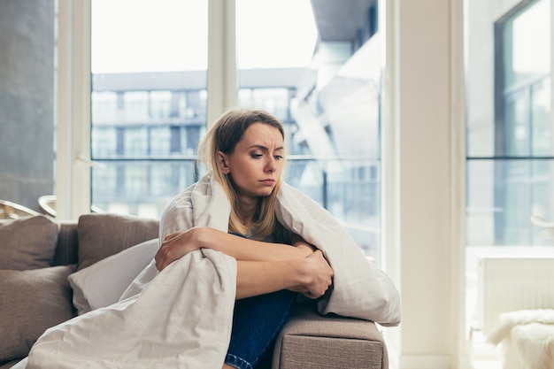  woman sitting on sofa at home depressed girl is having a hard time with stress