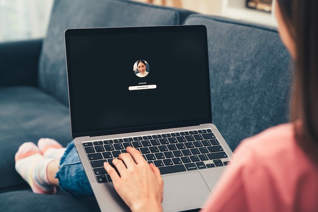 Woman sitting on sofa with typing the password on laptop computer, security and identification technology concept.