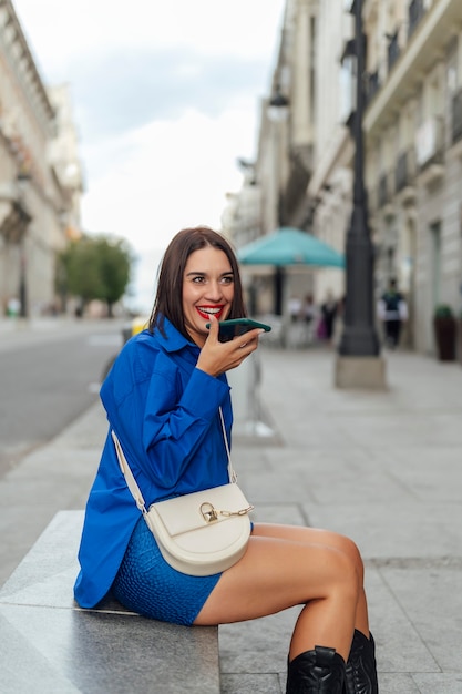 Woman sitting on the street calling on the phone