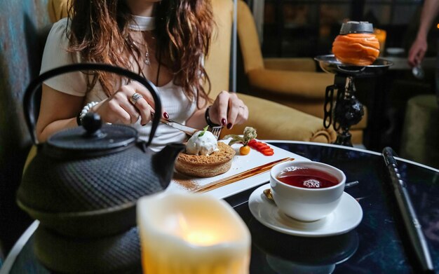 Woman Sitting at Table With Tea Kettle