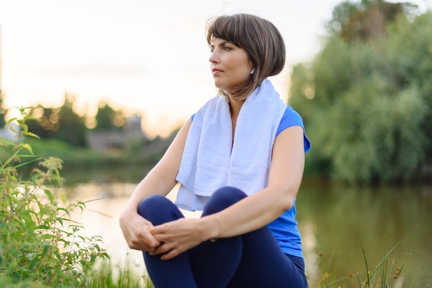 Woman sitting tired after fitness time in city park