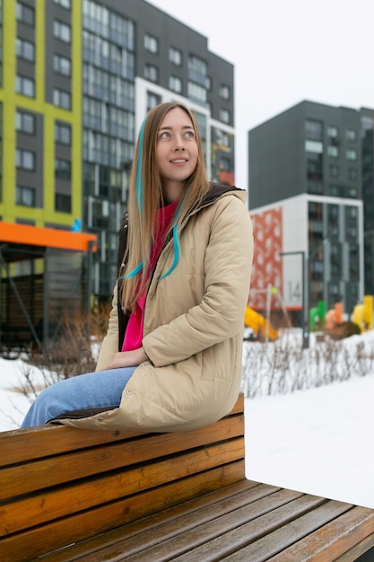 Woman sitting on top of wooden bench