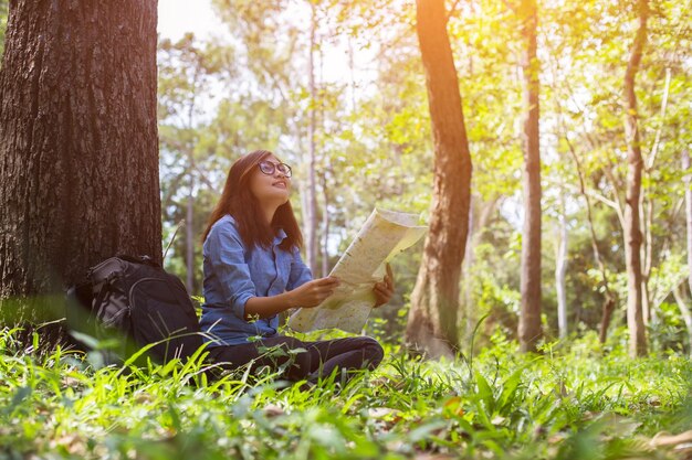 Photo woman sitting on tree trunk in forest