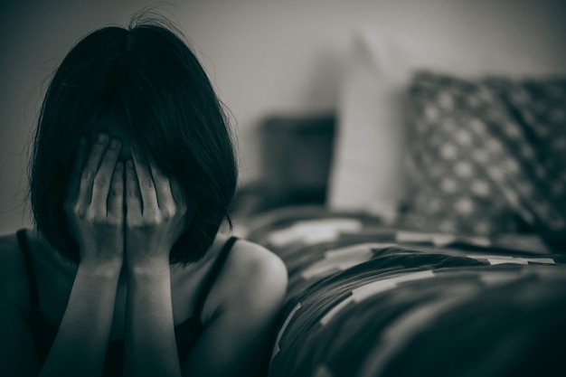 Woman sitting with hands covering her face in mourning from disappointment in life