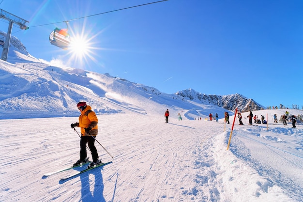 Woman Skier skiing at Hintertux Glacier in Tyrol in Mayrhofen of Austria, winter Alps. Lady girl Ski at Hintertuxer Gletscher in Alpine mountains with white snow and blue sky. Sun shining.