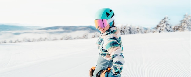 Woman in skiing clothes with helmet and ski googles on her head with ski sticks Winter weather on the slopes Mountain and enjoying view Alpine skier Winter sport Ski touring