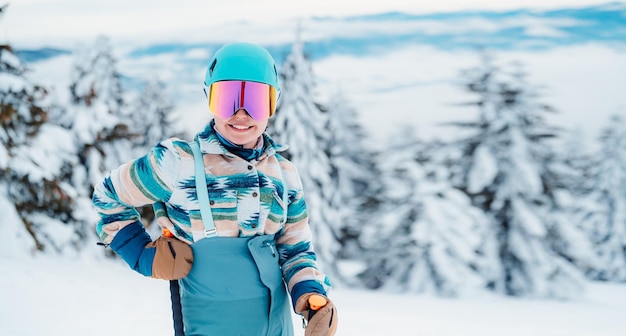 Woman in skiing clothes with helmet and ski googles on her head with ski sticks Winter weather on the slopes On top of a mountain and enjoying view Alpine skier Winter sport