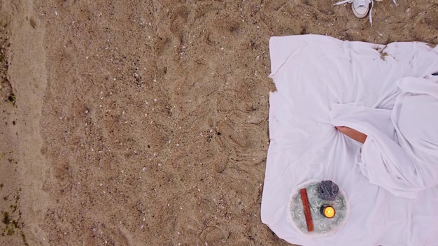 Woman sleeping on beach in bed in sunset