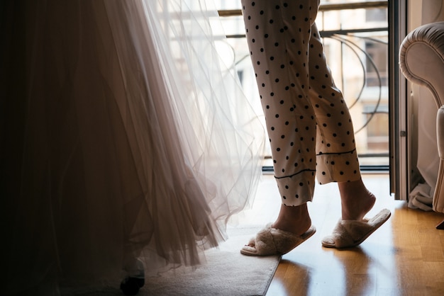 Woman in slippers and pajamas in her living room