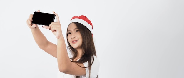 Woman and smartphone. Asian woman with smartphone in hand which posing like selfie or video call for online celebration in Christmas and new year festival season. Teenage braces happy and smartphone.