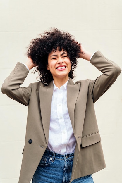 Woman smiles happy shaking her curly hair