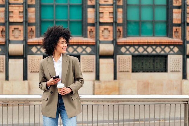 Woman smiles happy with a mobile phone in the hand