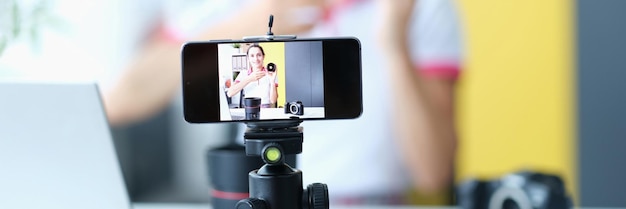 Woman smiling at camera while recording lens review for followers influencer on social media