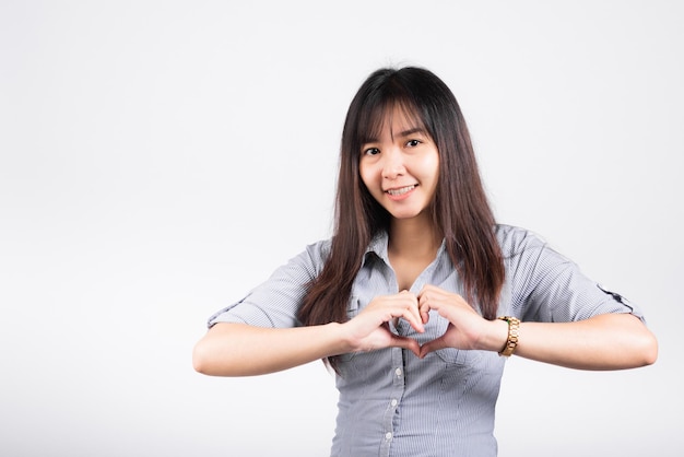 Woman smiling confidence make finger heart gesture figure symbol shape sign with two hands isolated white background, Asian happy portrait beautiful young female send love and happy valentine