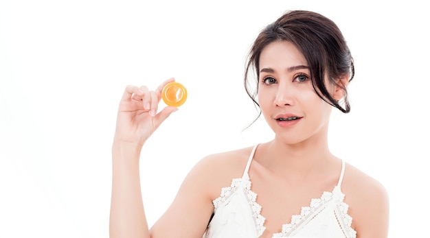 Woman smiling she's holding orange handcrafted organic soap