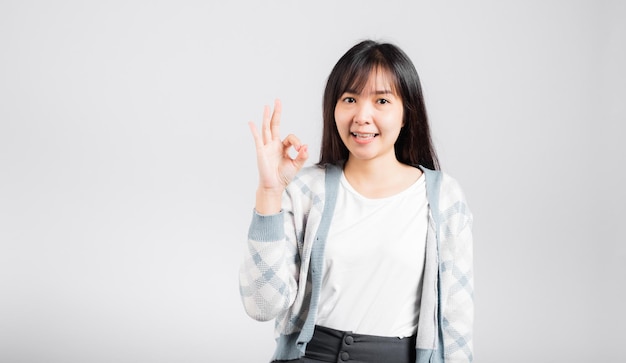 Woman smiling showing made finger OK symbol sign to agree