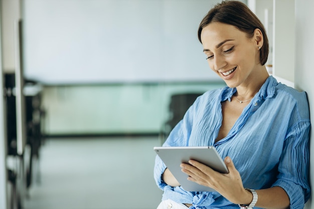 Woman smiling and using tablet in office