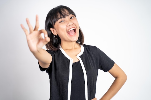 Woman smiling with okay hand gesture on isolated background