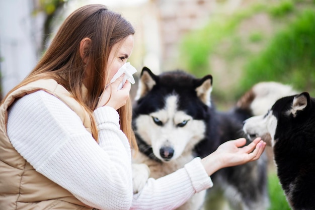 A woman sneezes and blows her nose into a napkin suffers from pet fur allergy