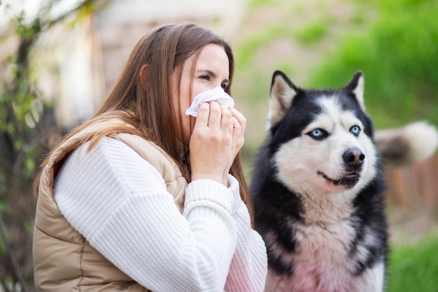 A woman sneezes and blows her nose into a napkin suffers from pet fur allergy