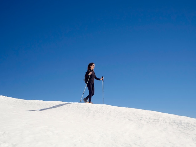 Woman snowshoeing in San Isidro, León, Spain on a sunny day