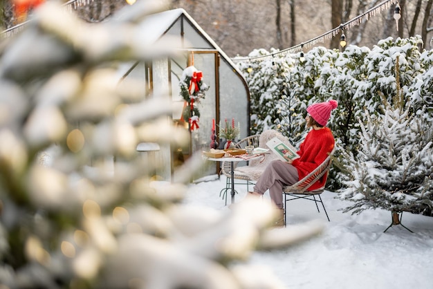 Woman at snowy backyard on winter holidays