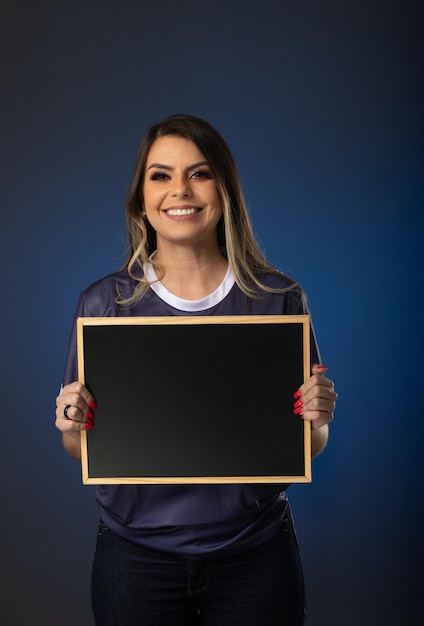 Woman soccer fan cheering for her favorite club and team world cup blue background Holding a blackboard