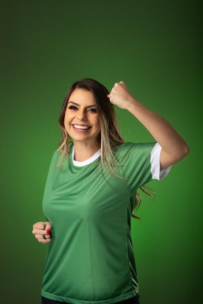 Woman soccer fan cheering for her favorite club and team world cup green background